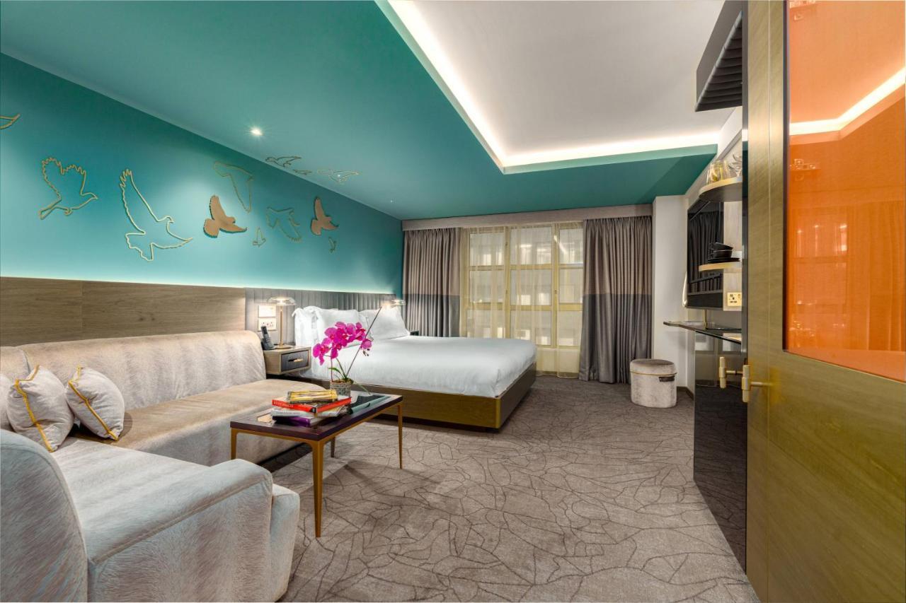 Middle Eight - Covent Garden - Preferred Hotels And Resorts Λονδίνο Εξωτερικό φωτογραφία The photo shows a modern hotel room featuring a blend of comfort and style. The room has a light-colored floor with a textured design, and the walls are adorned with a vibrant turquoise accent wall that features decorative butterfly motifs. 

There i