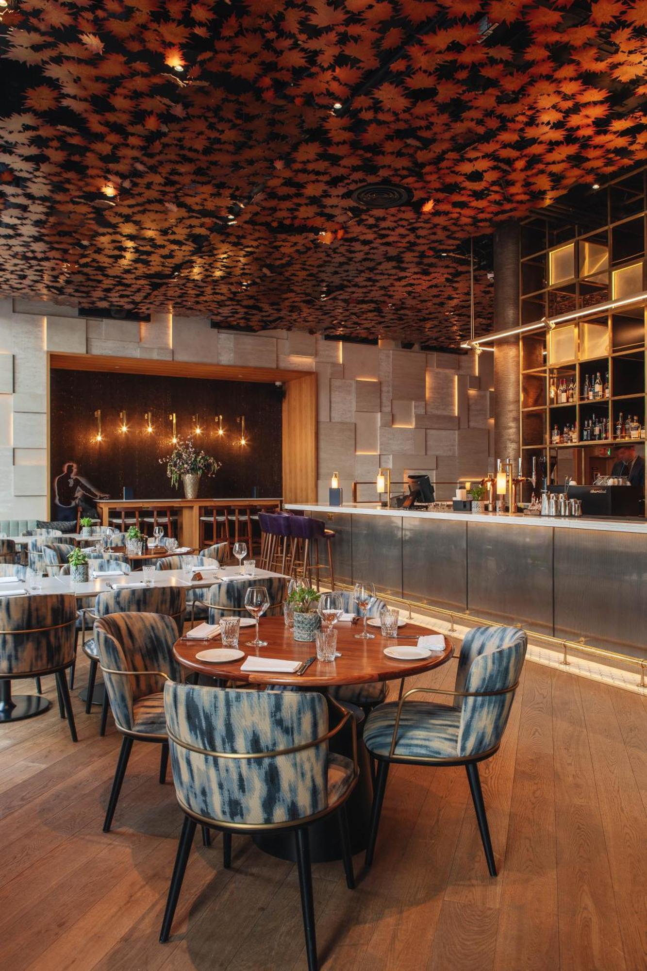Middle Eight - Covent Garden - Preferred Hotels And Resorts Λονδίνο Εξωτερικό φωτογραφία The photo shows a stylish restaurant interior. There are round tables set with plates and glasses, surrounded by comfortable chairs. The bar area is sleek and modern, with a counter displaying various bottles. The lighting appears warm and inviting, 